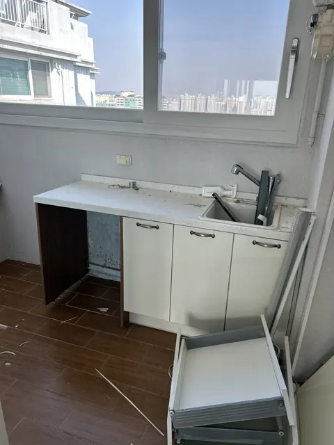 싱크대 하부장 교체 전 현장 현장 사진, 작은 싱크대에서 기존 하부장 도어와 서랍 자재가 분리된 상태